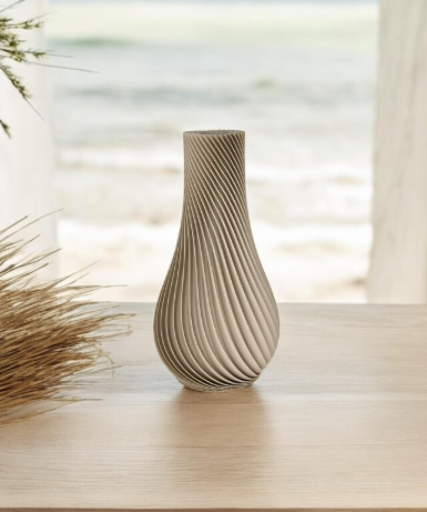 Modern beige 3D printed spiral vase with sculptural ribbed design styled in a coastal minimal home.