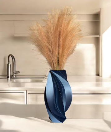 Blue 3D printed twisted sculptural vase featuring elegant flowing curves styled with pampas grass in a modern kitchen.