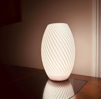 White spiral 3D printed lamp with sculptural lines creating a warm modern ambient light.